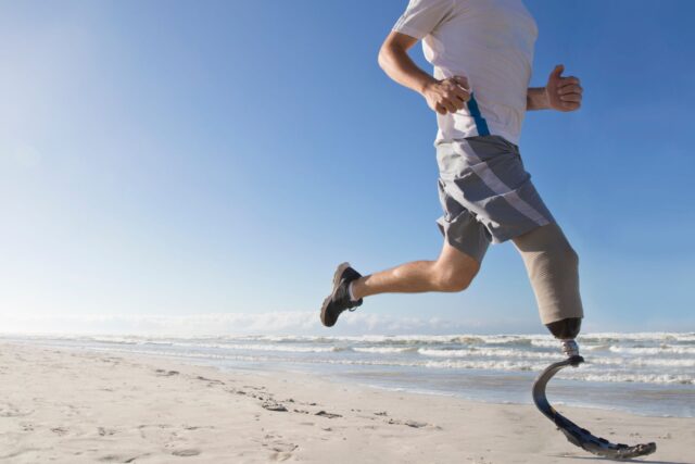 Man Running on a Beach with a Prosthetic Leg